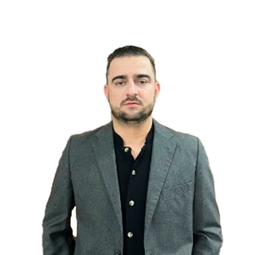 Profile picture of a person with short hair and a beard, wearing a black vest and white shirt, with a blurred outdoor background