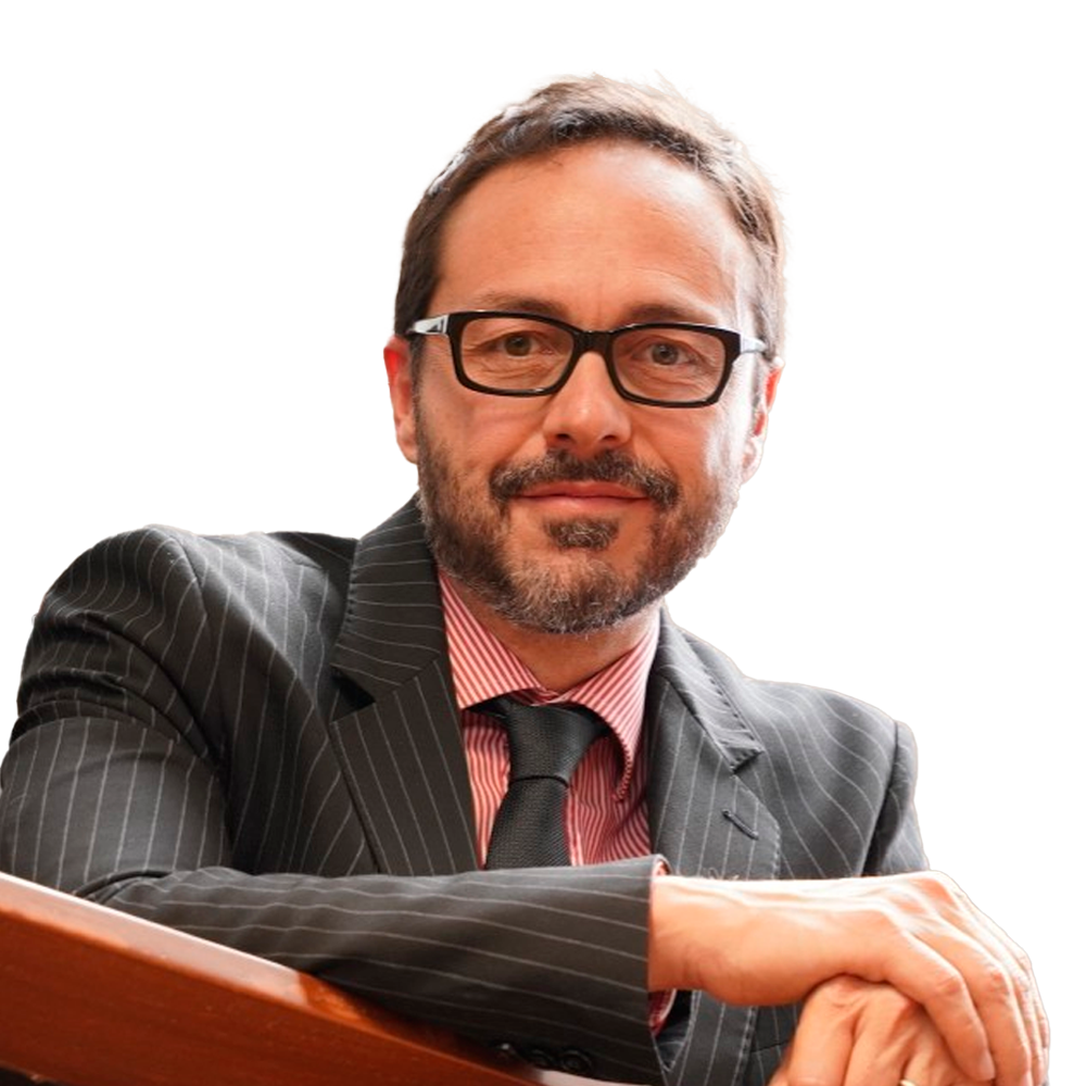 Profile picture of a person with short hair and a beard, wearing a black vest and white shirt, with a blurred outdoor background