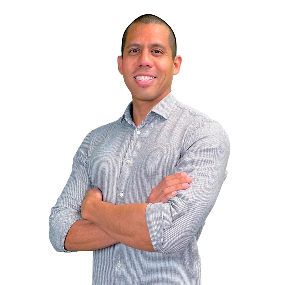 Profile picture of a person with short hair and a beard, wearing a black vest and white shirt, with a blurred outdoor background